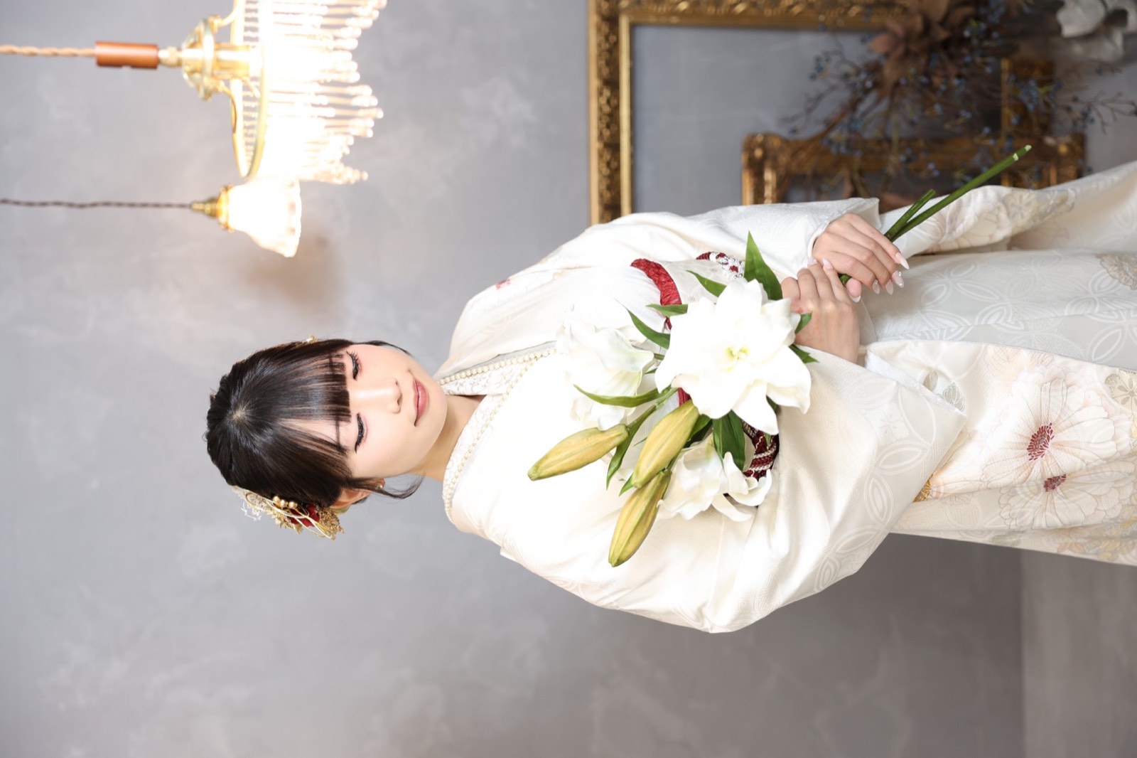 白い振袖姿で花を持ったスタジオ撮影