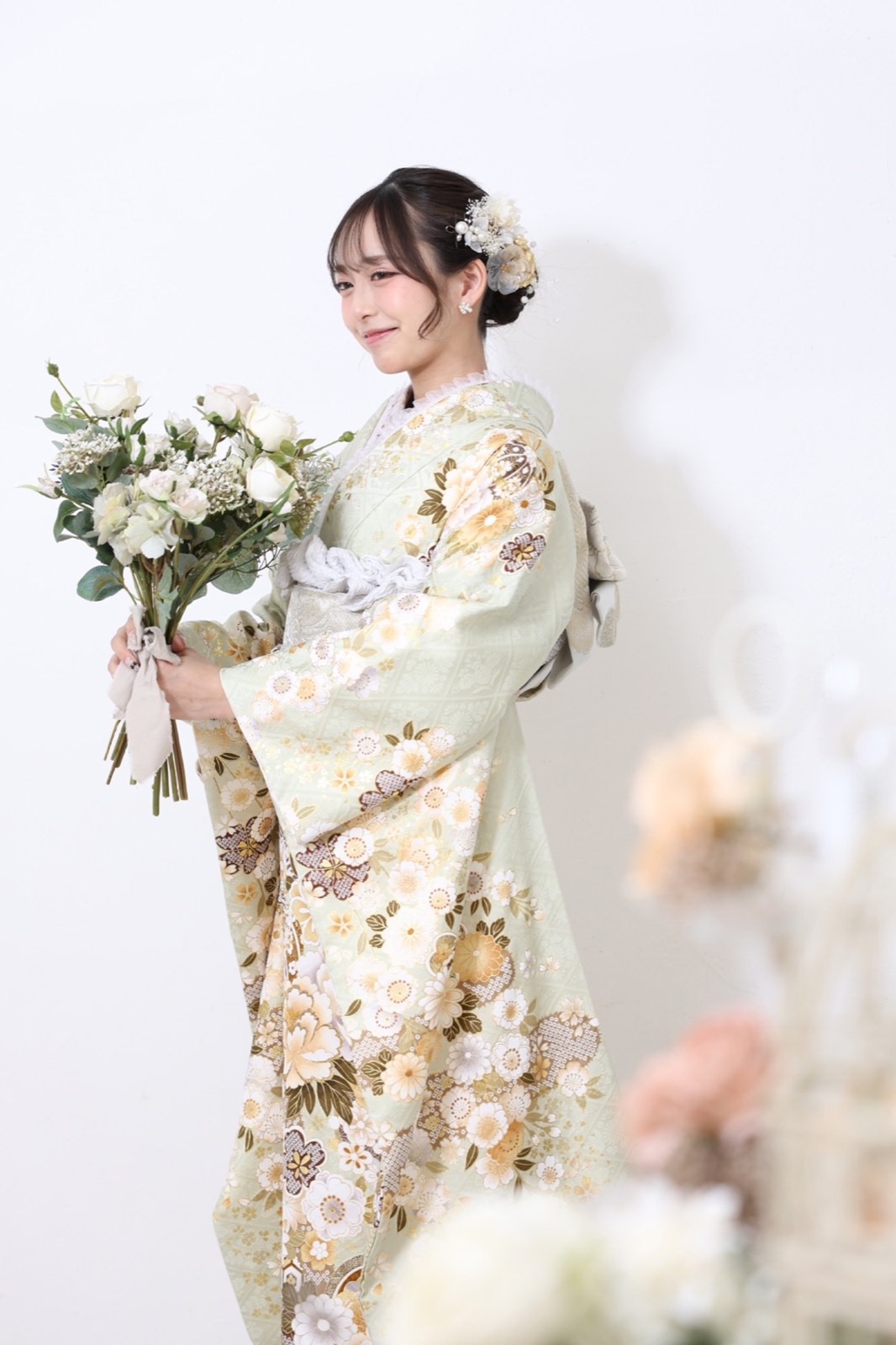 淡い緑の振袖姿で花束を持ったスタジオ撮影